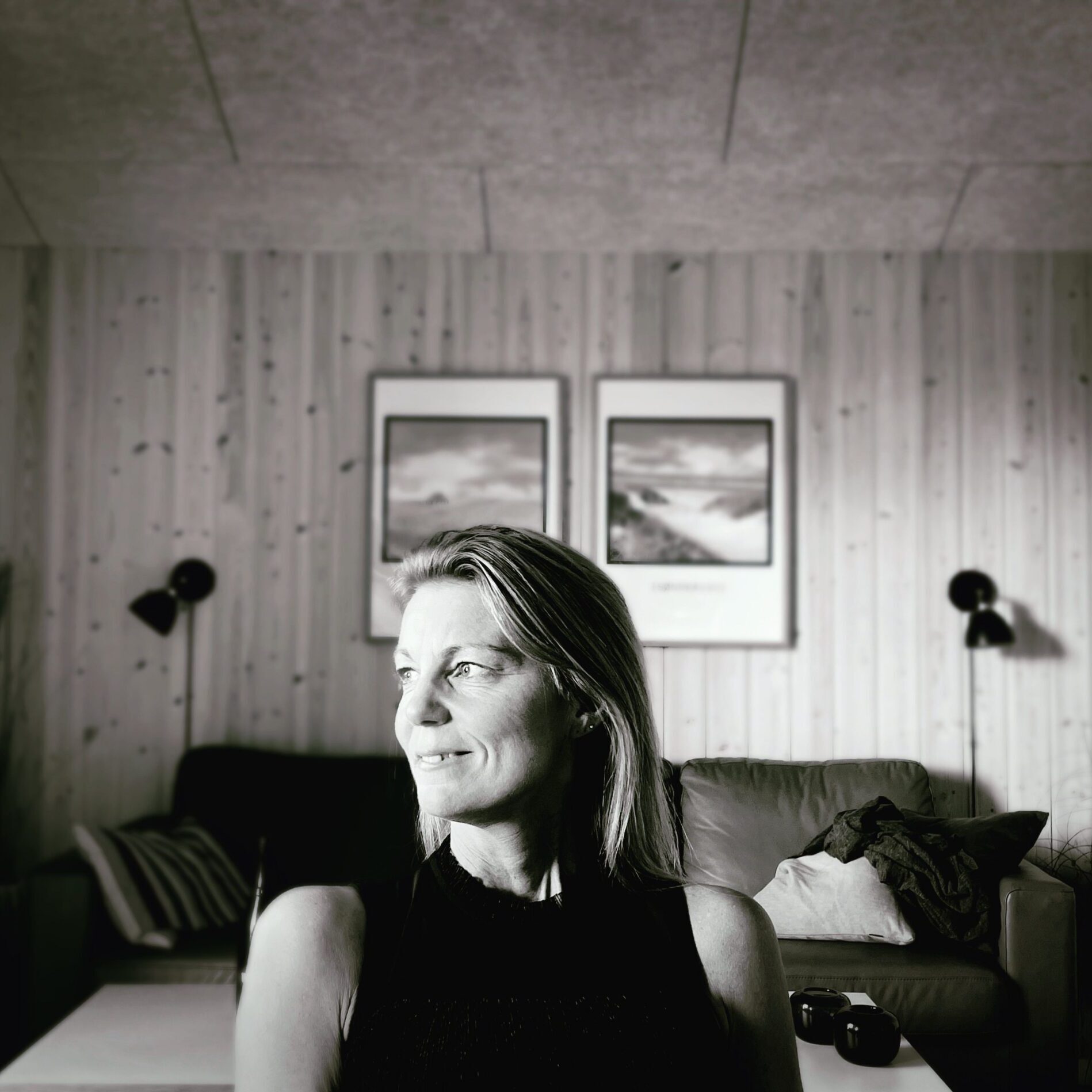 Front Page A serene black and white portrait of a woman sitting in a cozy living room.