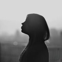 Front Page A striking silhouette of a woman in profile against a softly blurred cityscape background.