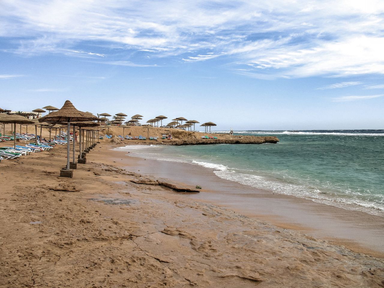Idyllic beach scene in Sharm El-Sheikh, Egypt with clear blue skies and calm sea.